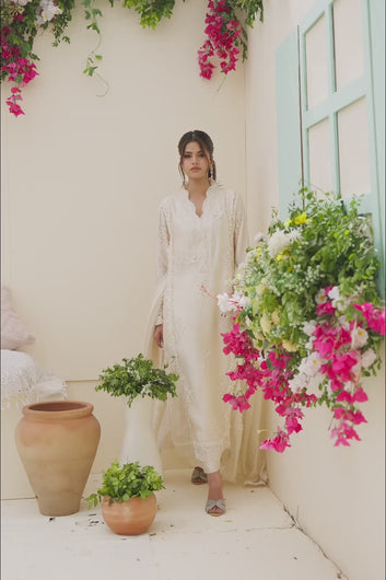 Video: Video showcase of a model wearing and moving in an ivory embroidered long shirt with matching trousers and a dupatta.
