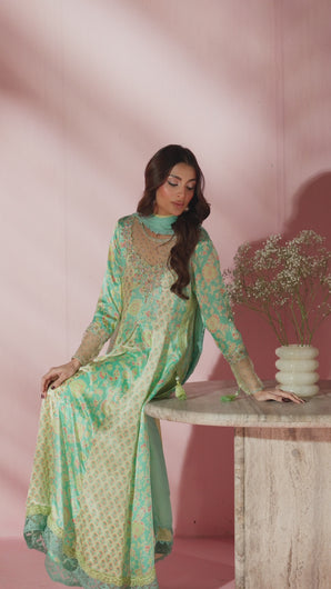 Video of model showcasing Jahanara two‑toned charmeuse silk kalidar with pleated panels, embellished neckline, and tassel accents, paired with butter silk pants and dupatta. 

